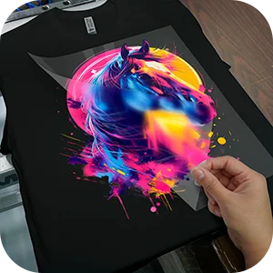 Hand peeling the clear film from a colorful horse design DTF transfer on a black t-shirt, demonstrating the peeling process.
